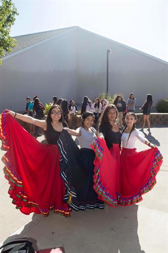 four girls wearing folk dance skirts